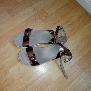 Gold sandals, approximate half an inch in height wrap around the ankle